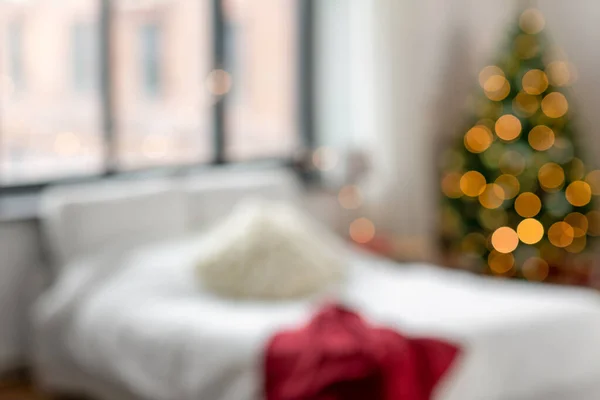 Cama borrada no quarto em casa aconchegante no Natal — Fotografia de Stock