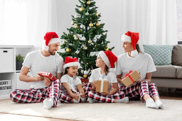 Ευτυχισμένη οικογένεια άνοιγμα χριστουγεννιάτικα δώρα στο σπίτι — Φωτογραφία Αρχείου