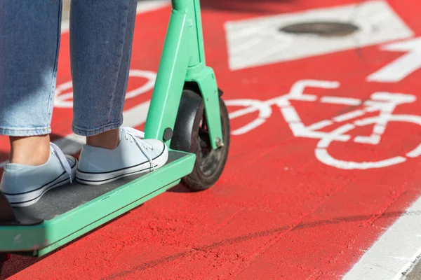 Mujer montando scooter a lo largo de carril bici carretera en la ciudad —  Fotos de Stock