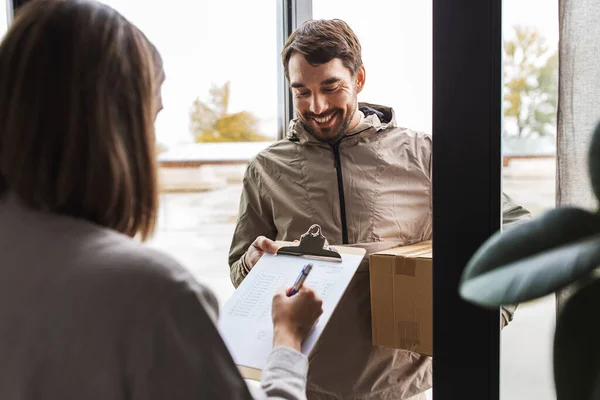 Hombre de entrega con caja de paquete y cliente en casa — Foto de Stock