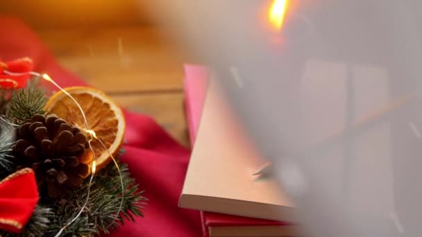 Krismas karangan bunga, buku, lilin, lentera pada jendela — Stok Video