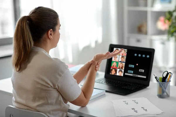 Vermoeide leraar met laptop aanraken pols thuis — Stockfoto