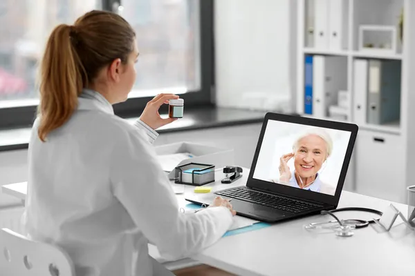 Médico con portátil que tiene videollamada con paciente —  Fotos de Stock