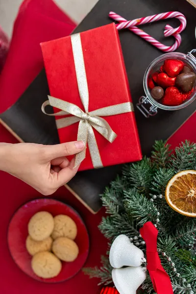 Mano con regalo di Natale, dolcetti e decorazioni — Foto Stock