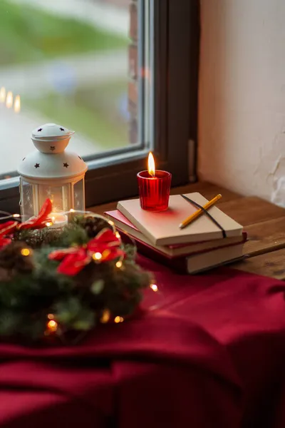 Χριστουγεννιάτικο στεφάνι, βιβλία, κεριά, φανάρι στο παράθυρο — Φωτογραφία Αρχείου