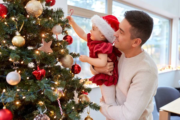 Ευτυχισμένος πατέρας και κοριτσάκι στολίζουν χριστουγεννιάτικο δέντρο — Φωτογραφία Αρχείου