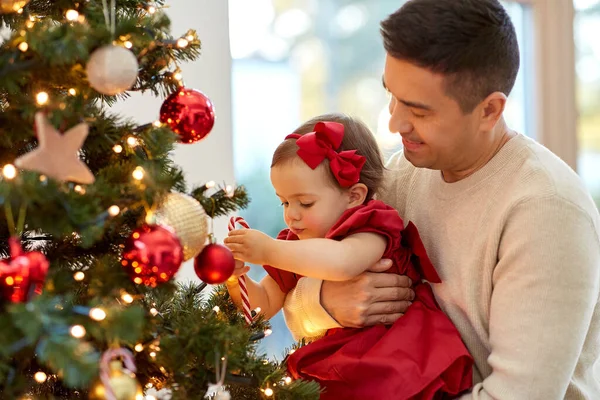 Mutlu baba ve kız bebek Noel ağacını süslüyor. — Stok fotoğraf