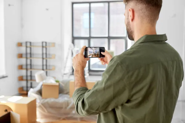 Hombre con teléfono inteligente tomando fotos de un nuevo hogar —  Fotos de Stock