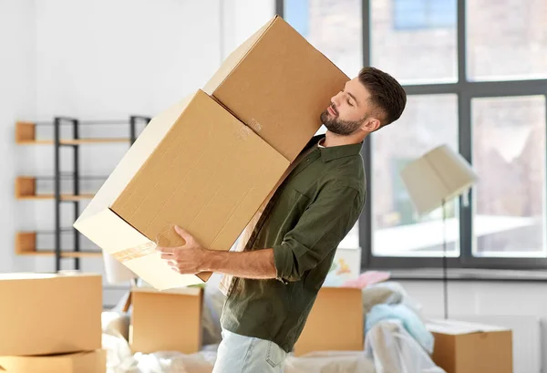 Happy man with boxes moving to new home — Stock Photo, Image