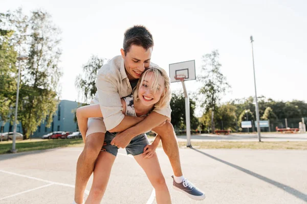 Feliz pareja divirtiéndose en baloncesto parque infantil —  Fotos de Stock