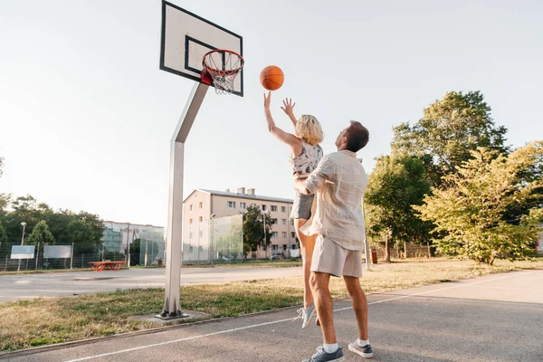 Happy couple playing on basketball on playground — Stock Photo, Image