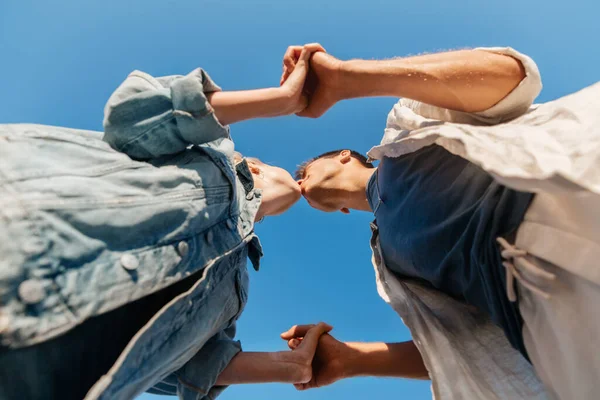 Feliz jovem casal beijando sob o céu azul — Fotografia de Stock