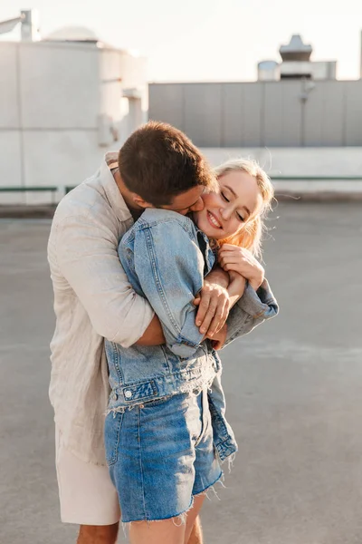 Feliz joven pareja abrazándose en la ciudad estacionamiento — Foto de Stock