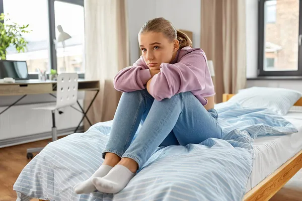 집에서 침대에 앉아 있는 슬픈 소녀 — 스톡 사진