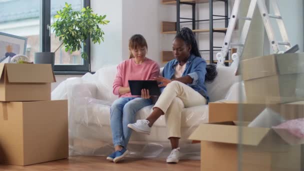 Женщины с планшетным ПК переезжают в новый дом — стоковое видео