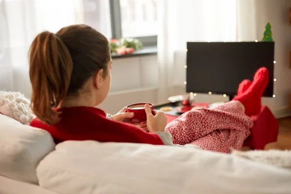 Žena sledování televize a pití kávy na Vánoce — Stock fotografie