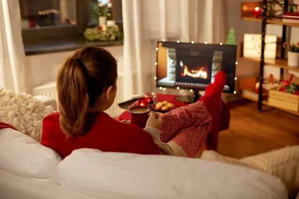 Femme regardant la télévision et buvant du café à Noël — Photo