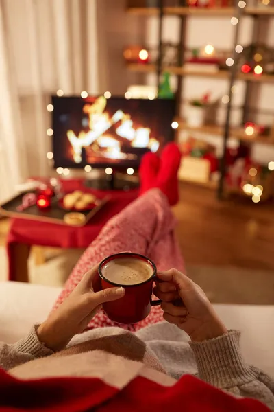 圣诞节时看电视和喝咖啡的女人 — 图库照片
