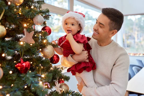 幸せな父親と赤ちゃんの女の子はクリスマスツリーを飾る — ストック写真