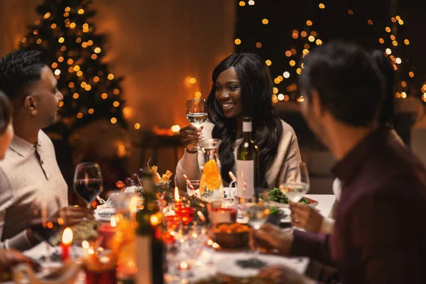 Amigos felices bebiendo vino en la fiesta de Navidad —  Fotos de Stock