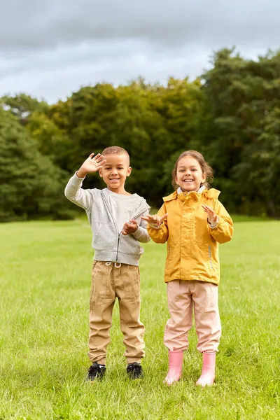 Счастливые мальчик и девочка в парке — стоковое фото