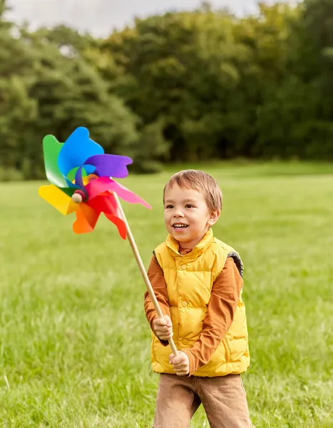 Szczęśliwy mały chłopiec z pinwheel zabawy w parku — Zdjęcie stockowe