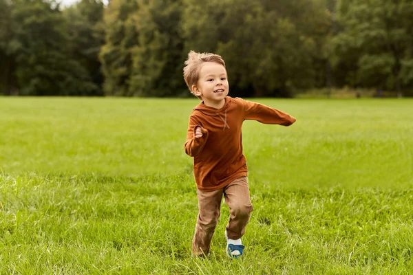 Niño feliz corriendo en el parque —  Fotos de Stock