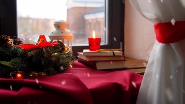 Рождественский венок, книги, свечи, фонарь на окне — стоковое видео