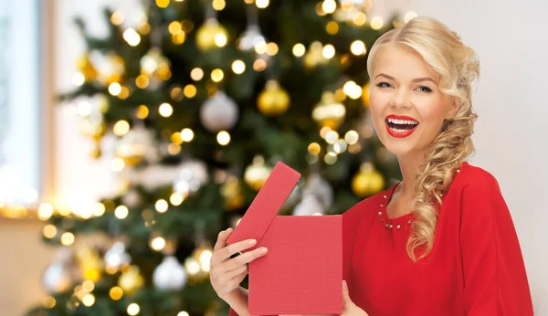 Schöne Frau im roten Kleid mit Weihnachtsgeschenk — Stockfoto