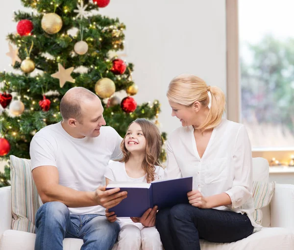 Happy family reading book at home on christmas — Stock Photo, Image