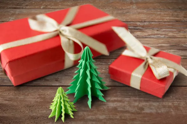 Cajas de regalo y árboles de Navidad en tablas de madera — Foto de Stock