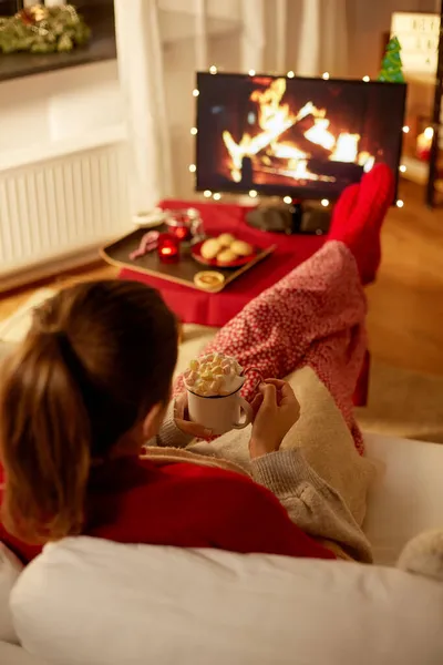 Mujer viendo la televisión con malvavisco en Navidad —  Fotos de Stock