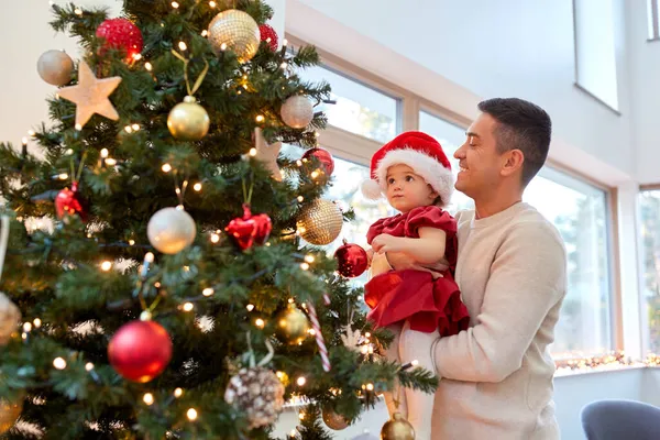 Mutlu baba ve kız bebek Noel ağacını süslüyor. — Stok fotoğraf