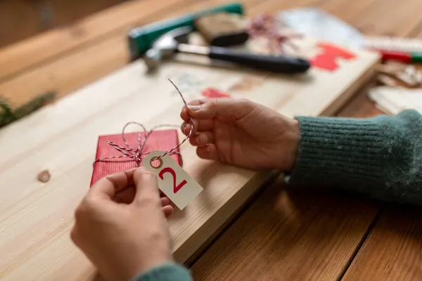 Mulher fazendo calendário de advento no Natal em casa — Fotografia de Stock