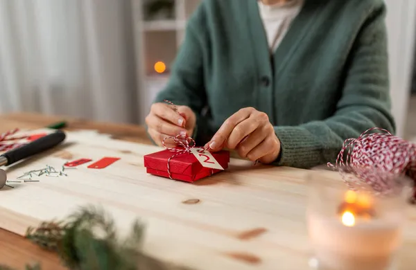 クリスマスに自宅でアドベントカレンダーを作る女性は — ストック写真