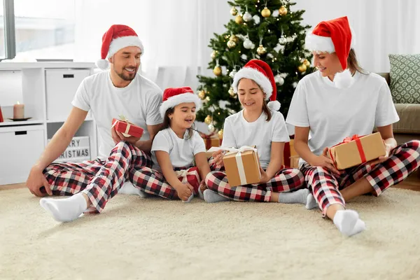 Счастливая семья с рождественскими подарками дома — стоковое фото