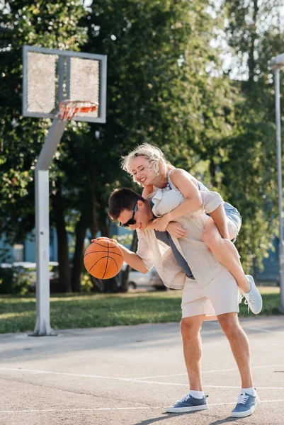 Feliz pareja divirtiéndose en baloncesto parque infantil — Foto de Stock