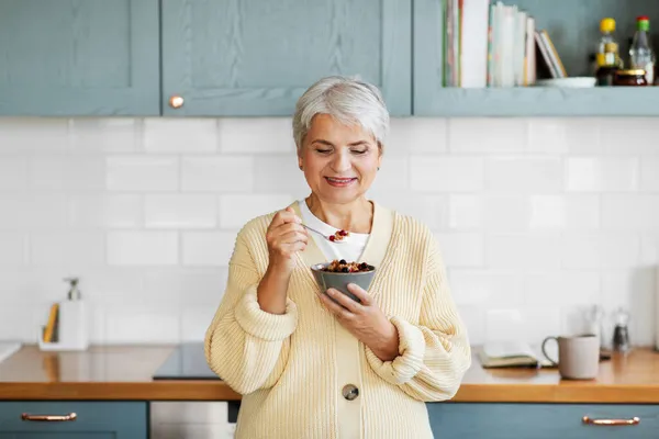 Mujer con cereal para el desayuno en la cocina en casa — Foto de Stock