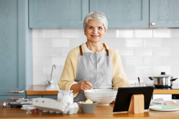 Mujer con la computadora de la tableta cocinar alimentos en la cocina — Foto de Stock
