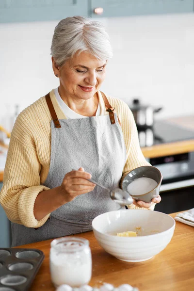 Счастливая женщина готовит еду на кухне дома — стоковое фото
