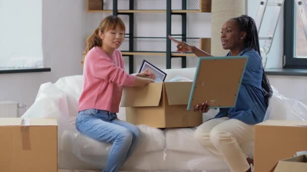 Mujeres desempacando cajas y mudándose a un nuevo hogar — Vídeo de stock