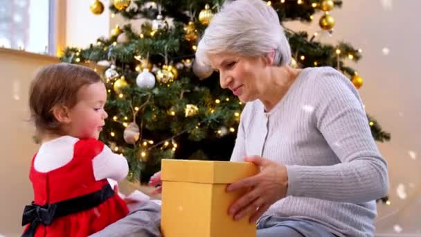 Oma en baby meisje met kerstcadeaus — Stockvideo