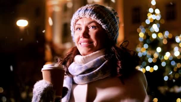 クリスマスライトの上でコーヒーを飲む幸せな女性 — ストック動画