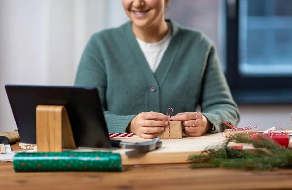 Tabletli mutlu kadın Noel hediyesi paketliyor. — Stok fotoğraf