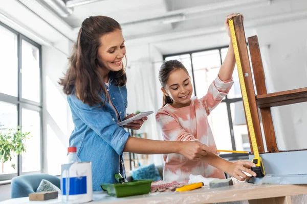 Mutter und Tochter mit Lineal messen alten Tisch — Stockfoto