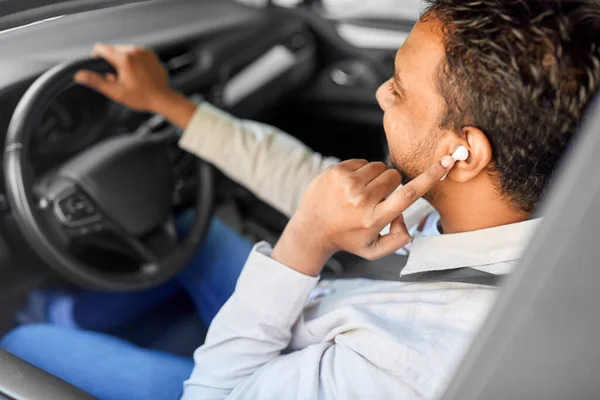 Człowiek lub kierowca z bezprzewodowymi słuchawkami jazdy samochodem — Zdjęcie stockowe