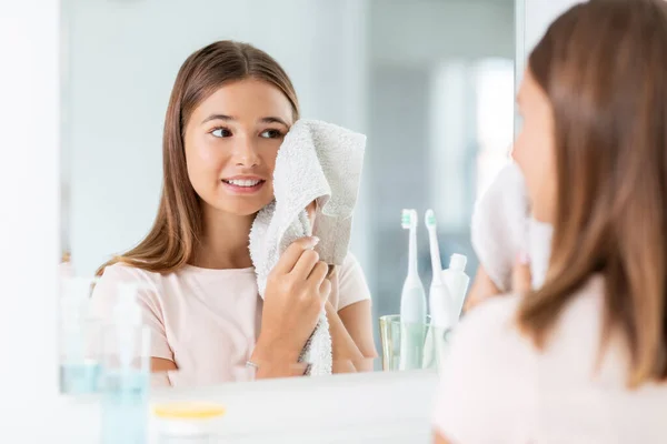 Adolescente esfregando rosto com toalha no banheiro — Fotografia de Stock