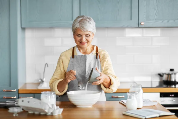 Mulher feliz cozinhar comida na cozinha em casa — Fotografia de Stock