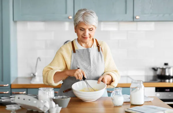 Mulher feliz cozinhar comida na cozinha em casa — Fotografia de Stock