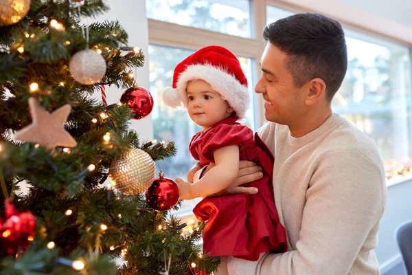 Mutlu baba ve kız bebek Noel ağacını süslüyor. — Stok fotoğraf